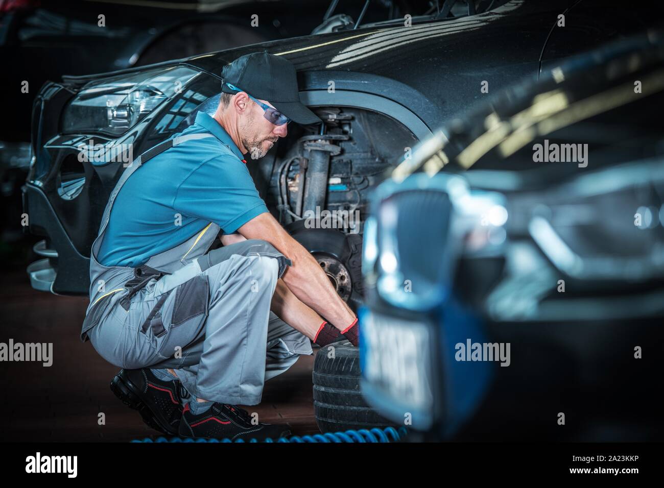 Kaukasische Automechaniker und seine Automotive Job. Auto Service Shop. Wartung modernes Fahrzeug Bremsen. Stockfoto