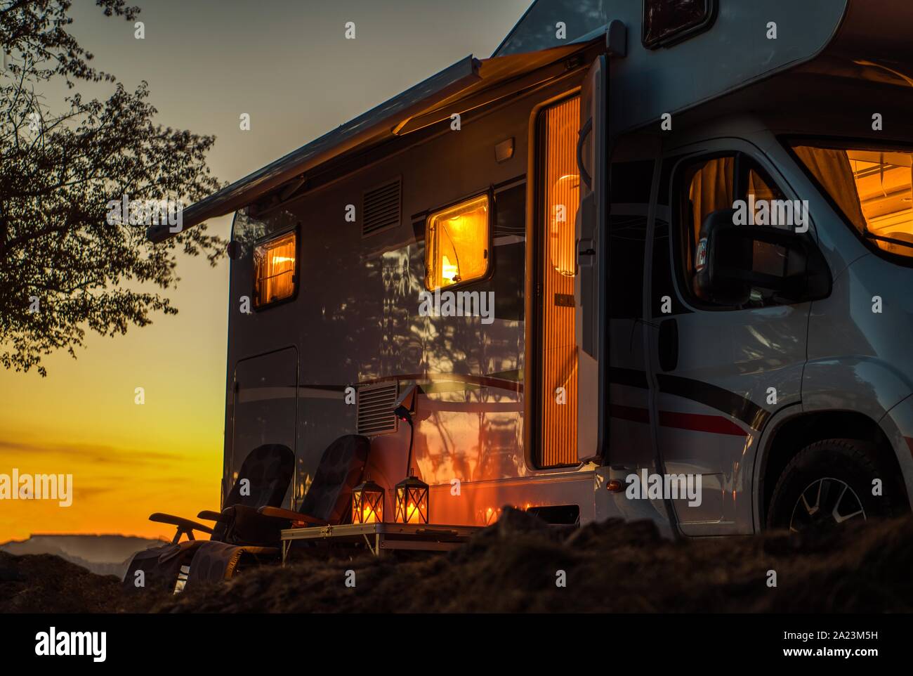 Scenic RV Camping Spot während des Sonnenuntergangs. Klasse C Reisemobil Wohnmobil. Travel Industry Thema. Stockfoto