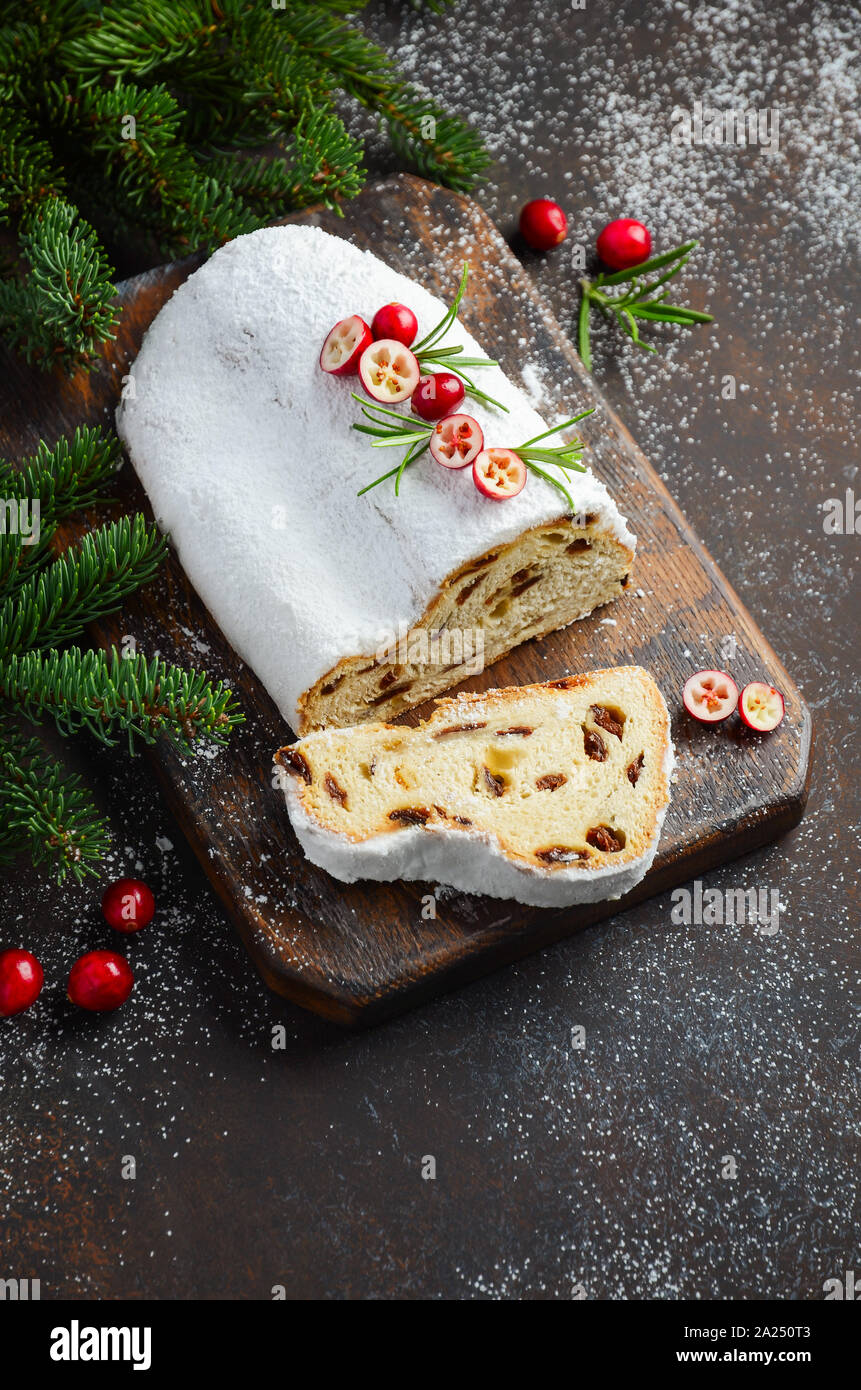 Christstollen. Traditionelle deutsche, europäische festlichen Nachtisch. Urlaub Konzept dekoriert mit Tannenzweigen und Preiselbeeren. Stockfoto