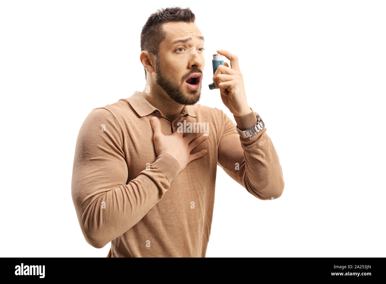 Junger Mann mit Atembeschwerden mit einem Inhalator auf weißem Hintergrund Stockfoto