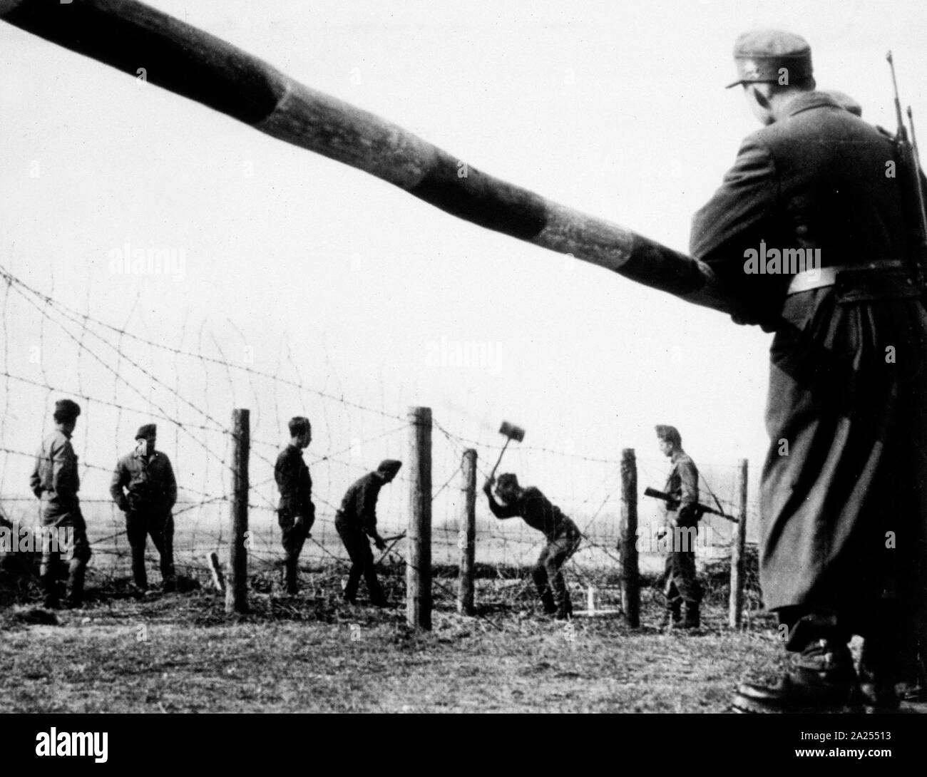 Ungarische Soldaten Reparatur Stacheldraht Einzäunung auf der österreichisch-ungarischen Grenze im Jahr 1957. Dies folgt einer Zuspitzung der Spannungen nach dem ungarischen Aufstand von 1956 Stockfoto