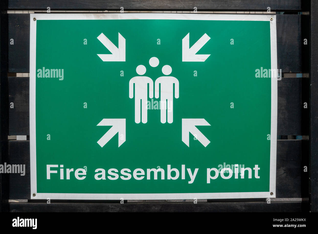 Sammelplatz im Brandfall zu einem schwarz lackierten hölzernen Zaun befestigt Stockfoto