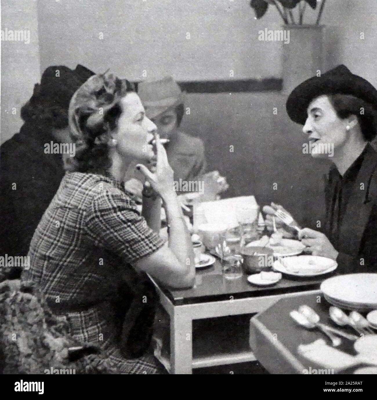 Zwei Frauen unterhalten und Rauch während eines Mittagessens, London ca. 1947 Stockfoto