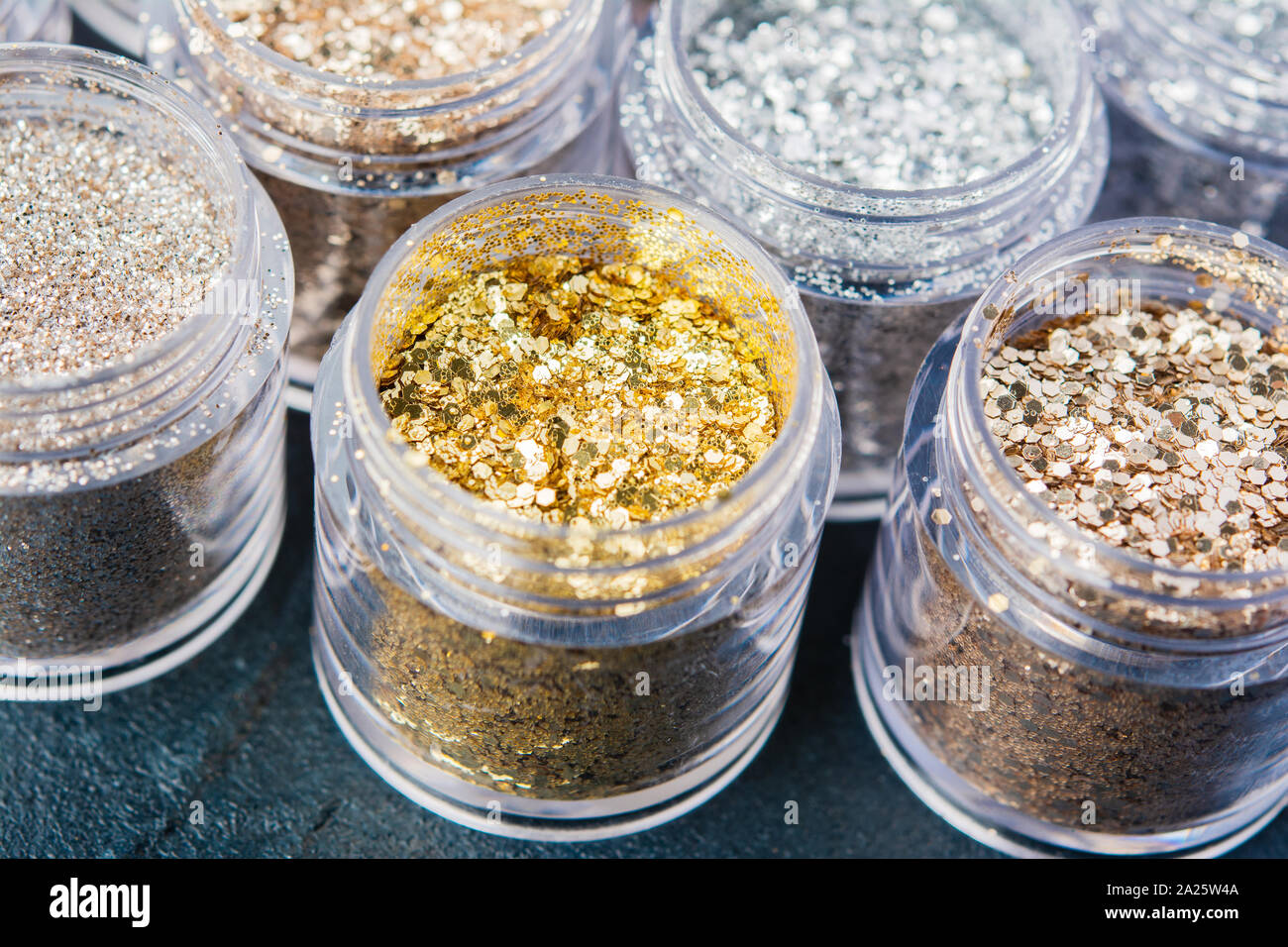 Schöne Glitzer in goldenen und silbernen Abstufungen in kleinen Gläsern, selektiver Fokus Stockfoto
