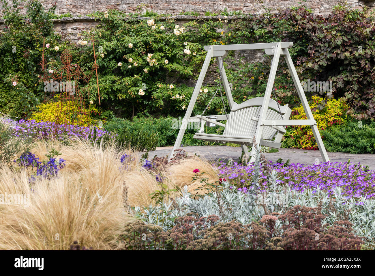 Einen bemalten swing Bank in den schönen Garten des Bishops Palace, Wells, Somerset, Großbritannien Stockfoto