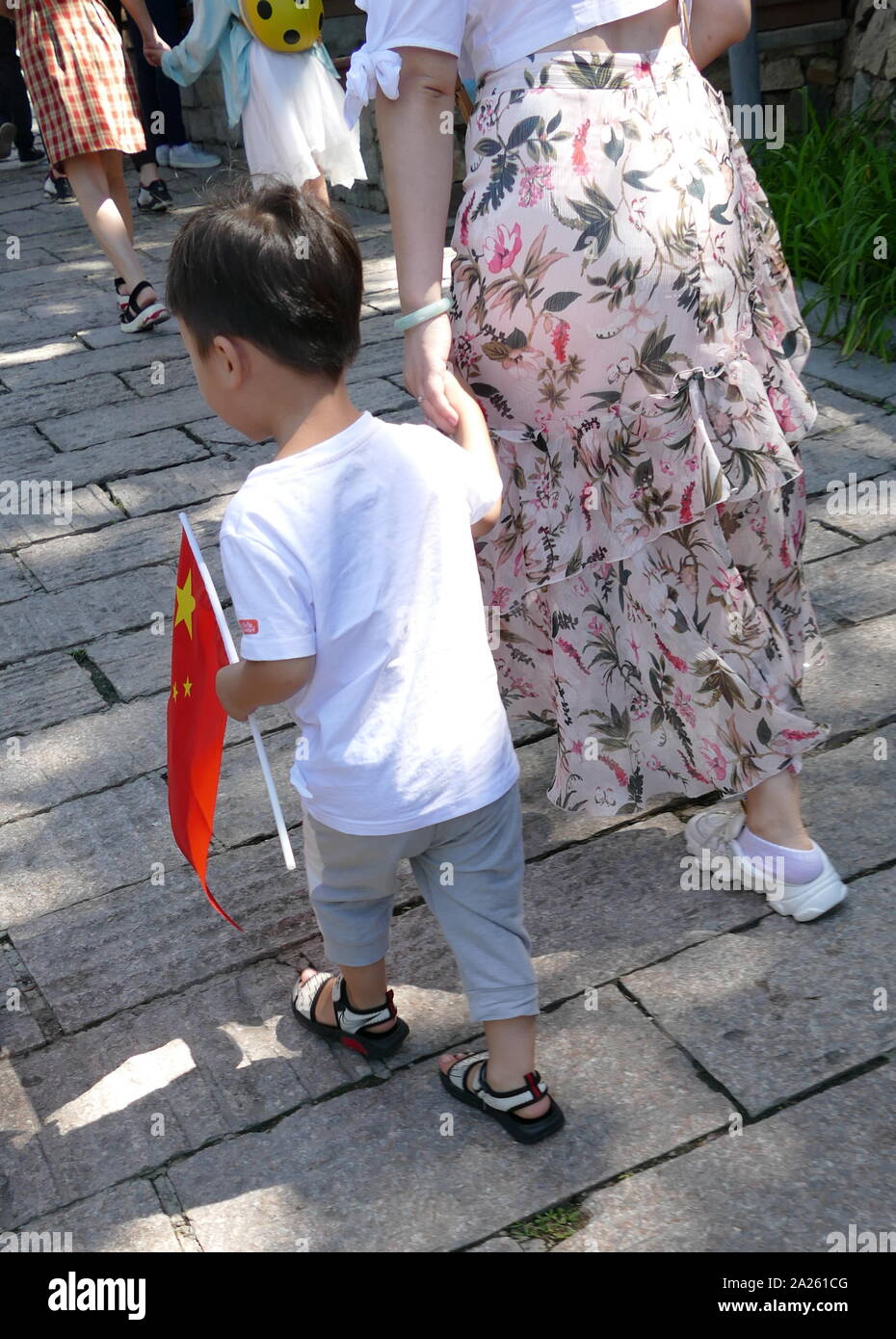 Chinesische Säugling mit der Nationalflagge. Die Demographie von China eine große Bevölkerung mit einem relativ kleinen Jugend Komponente, teilweise aufgrund von Chinas zwei Ein-kind-Politik demonstrieren. 2019, Chinas Bevölkerung steht bei 1.418 Milliarden, die größte aller Länder der Welt. Stockfoto