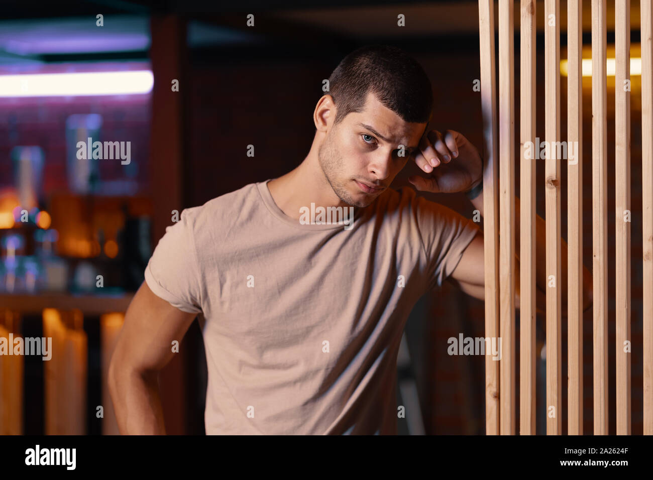 Close-up Portrait von attraktiven männlichen Models. Retro wave Porträt eines jungen Mannes in eine Bar. Modell in bunten hellen Neonlicht. Stockfoto