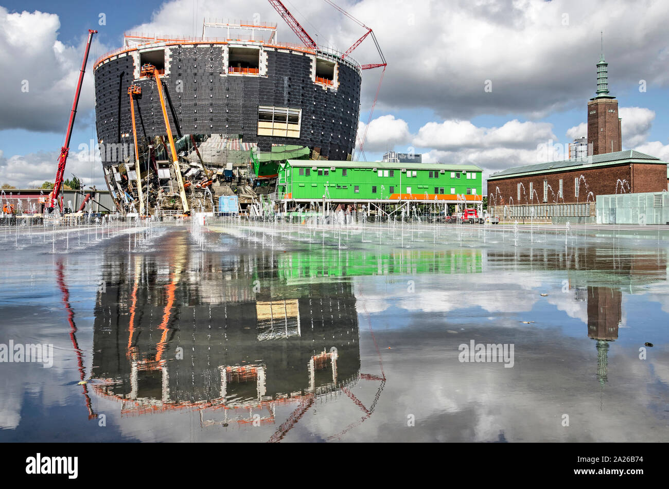 Rotterdam, Niederlande, 30. September, 2019: Die neue Kollektion Gebäude mit seiner Fassade im Bau wider spiegelt sich in den nassen Asphalt Stockfoto