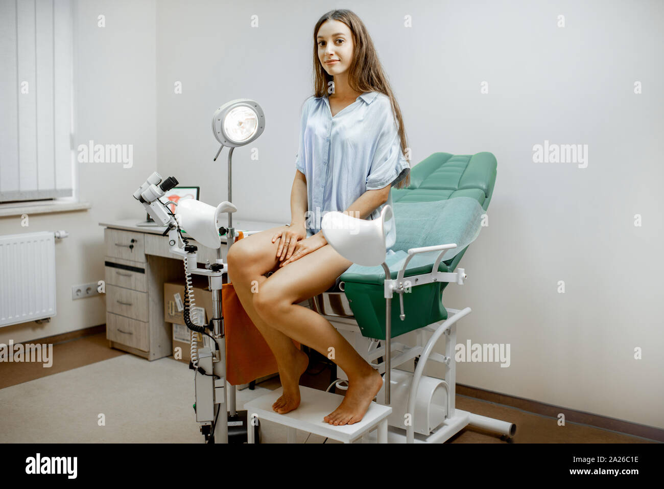 Frau sitzt auf dem gynäkologischen Stuhl, bevor Sie eine ärztliche  Untersuchung durch einen Gynäkologen im Büro Stockfotografie - Alamy
