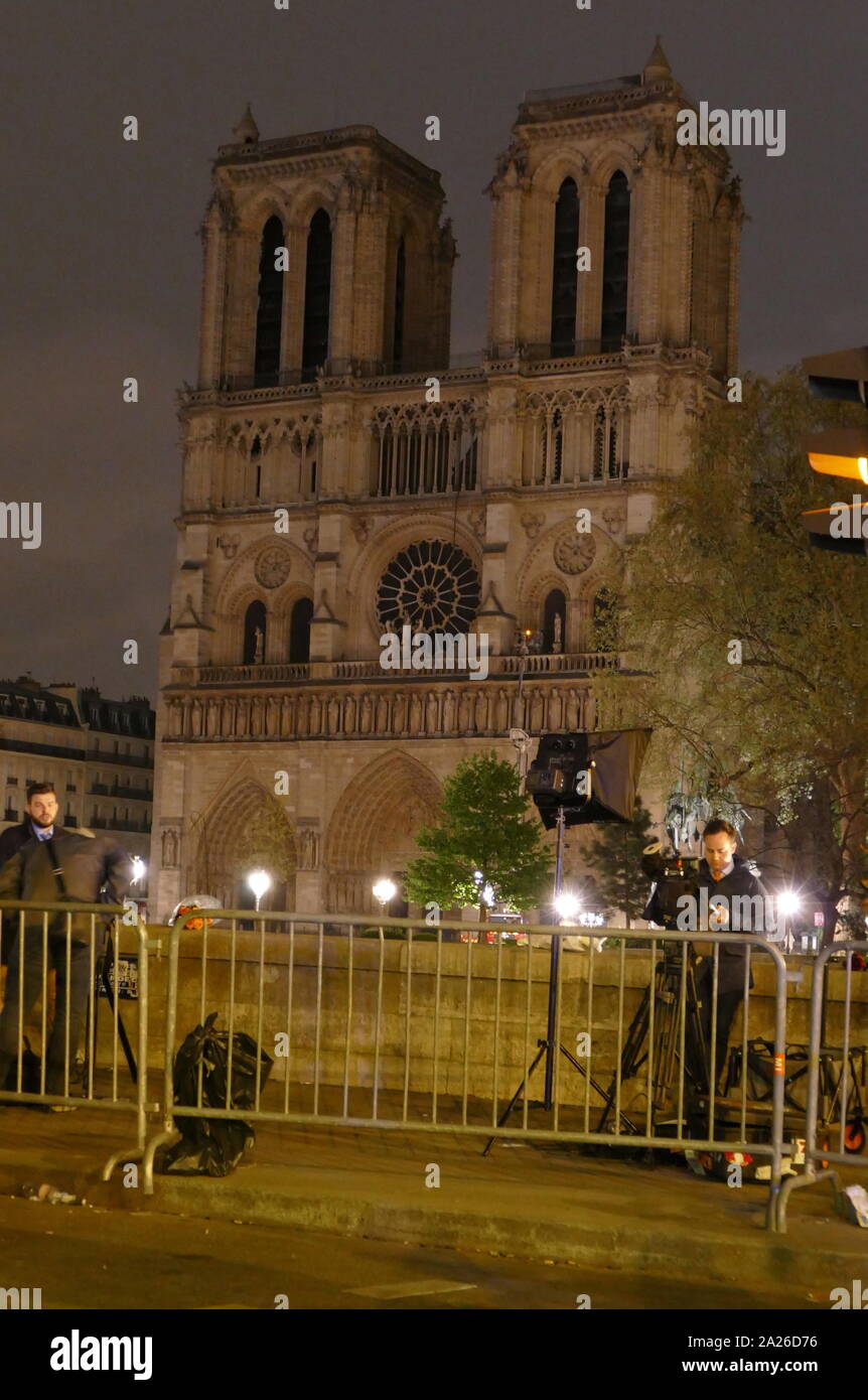 Szene, die Auswirkungen des Brandes, der Notre Dame Kathedrale beschädigt in der Nacht, in der der Brand gelöscht war. Polizei bewachen den Eingang zu der unbeleuchteten Kathedrale. Stockfoto