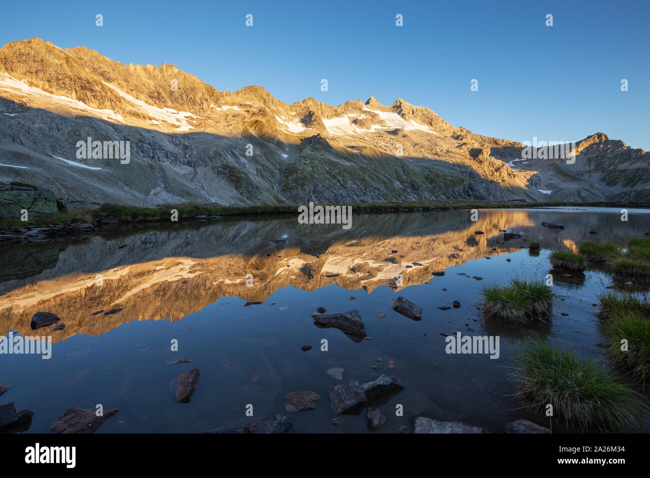 Peaks spiegelt sich auf alpinen See. Reichenspitzgruppe. Reichenspitze Peak. Sunrise Sonnenlicht auf Gipfel und Gletscher. Nationalpark Hohe Tauern Nationalpark. Stockfoto