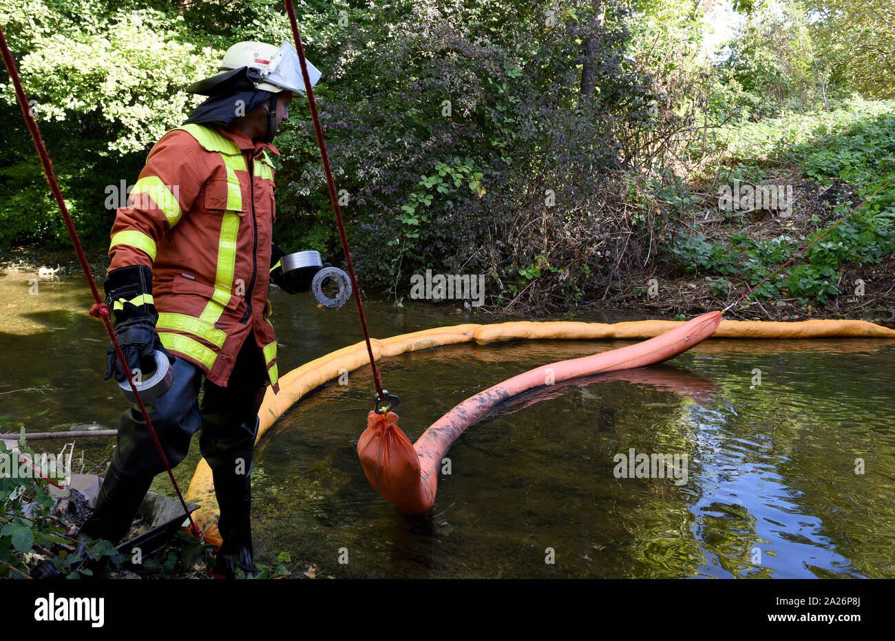 Aalen, Deutschland. 01 Okt, 2019. Ein Feuerwehrmann steht in den Herd neben einem Ölboom. Nach einem Lkw in den Fluss in einen Unfall gelandet war, die Feuerwehr Ölsperren errichtet. Das Fahrzeug nach links die Straße aus unbekannten Gründen, durchbrach eine Brücke Geländer und landete in den Fluss Kocher. Der Fahrer wurde leicht verletzt. Quelle: Stefan Puchner/dpa/Alamy leben Nachrichten Stockfoto Aalen, Deutschland. 01 Okt, 2019. Ein Feuerwehrmann steht in den Herd neben einem Ölboom. Nach einem Lkw in den Fluss in einen Unfall gelandet war, die Feuerwehr Ölsperren errichtet. Das Fahrzeug nach links die Straße aus unbekannten Gründen, durchbrach eine Brücke Geländer und landete in den Fluss Kocher. Der Fahrer wurde leicht verletzt. Quelle: Stefan Puchner/dpa/Alamy leben Nachrichten Stockfoto