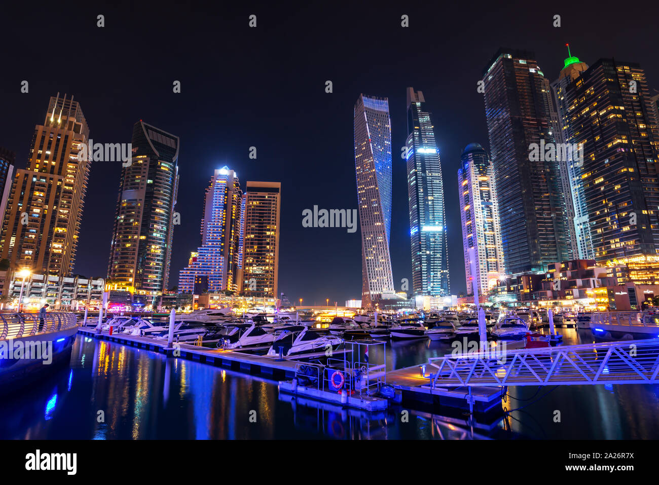 Der Yachthafen von Dubai Skyline bei Nacht mit Boote im Hafen, Vereinigte Arabische Emirate Stockfoto