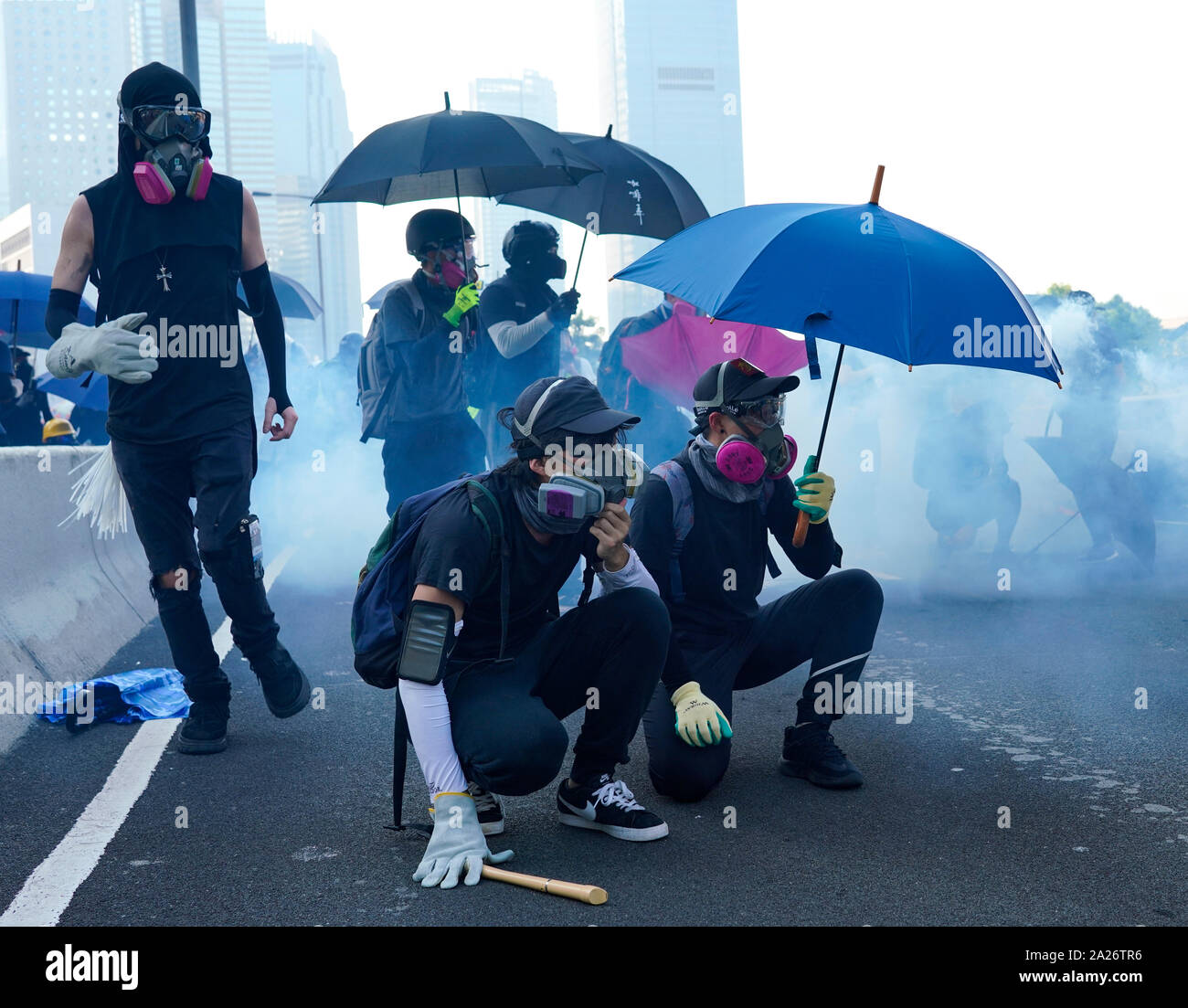 Hong Kong. 1. Oktober 2019. Nach einem friedlichen Marsch durch Hong Kong Island von schätzungsweise 100.000 pro Demokratie Unterstützer, gewalttätige Flammte auf Tamar, Admiralty und bewegte sich durch Wanchai Bezirk. Die Polizei setzte Tränengas, Knüppel und Wasserwerfer. Harter Kern Gruppe Feuer, warf Steine und Molotow-Cocktails auf Polizisten. Die Gewalt in den Abend. Demonstranten Tierheim form Tränengas. Iain Masterton/Alamy Leben Nachrichten. Stockfoto