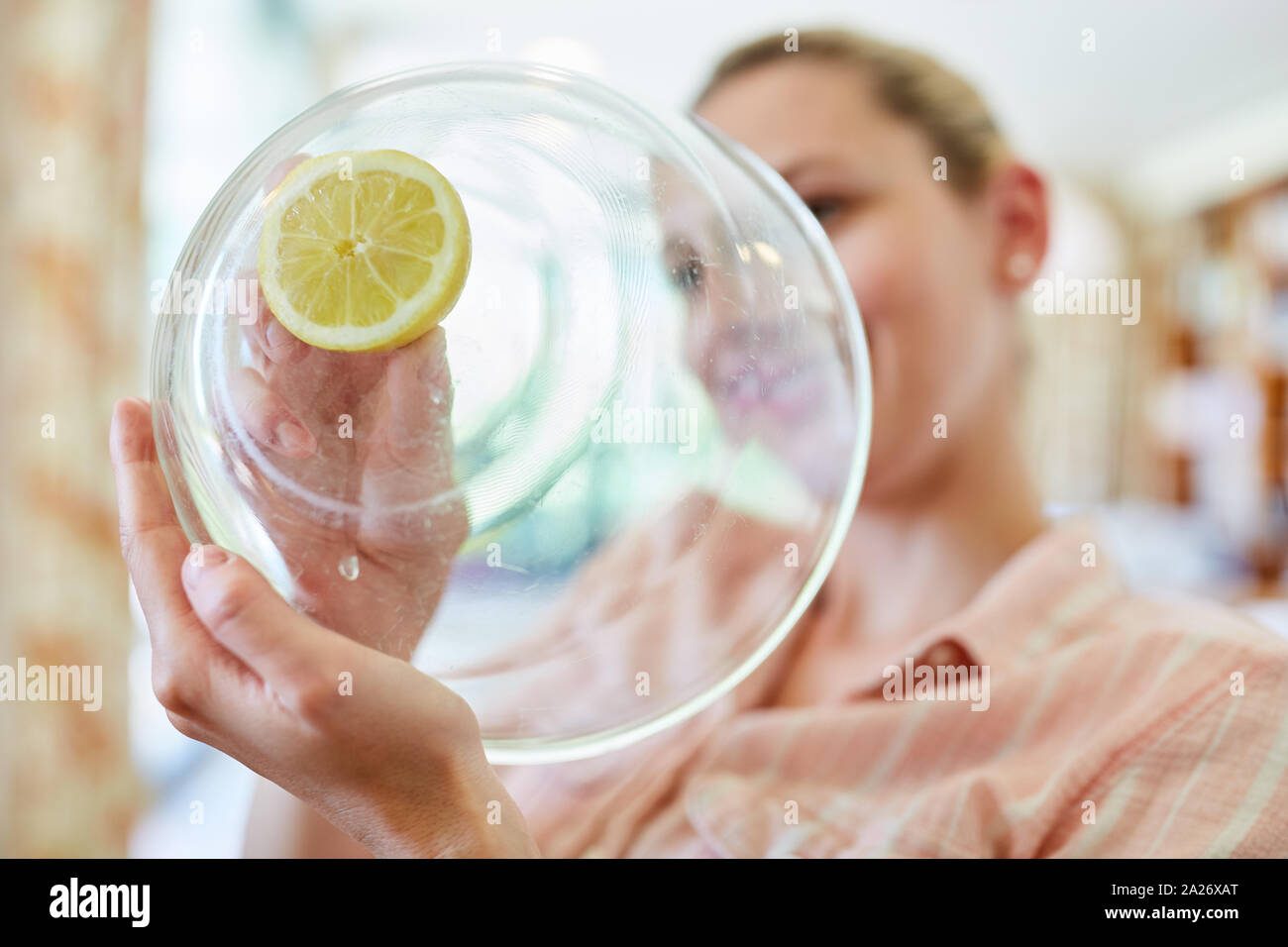Hausfrau oder Zimmermädchen reinigt Glas der Zitronensäure Schüssel als Haupthilfsmittel Stockfoto