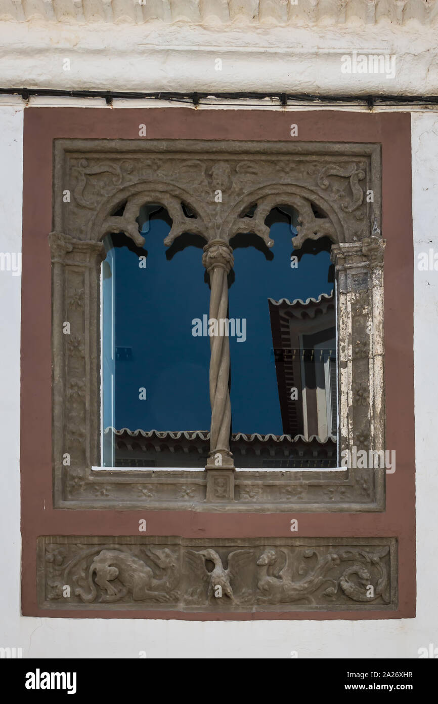 Historische verzierten Fenster, aufgeteilt in zwei Teile. Die blauen Himmel und eine gegenüberliegende Haus. Ribeira Grande, Sao Miguel, Azoren, Portugal. Stockfoto