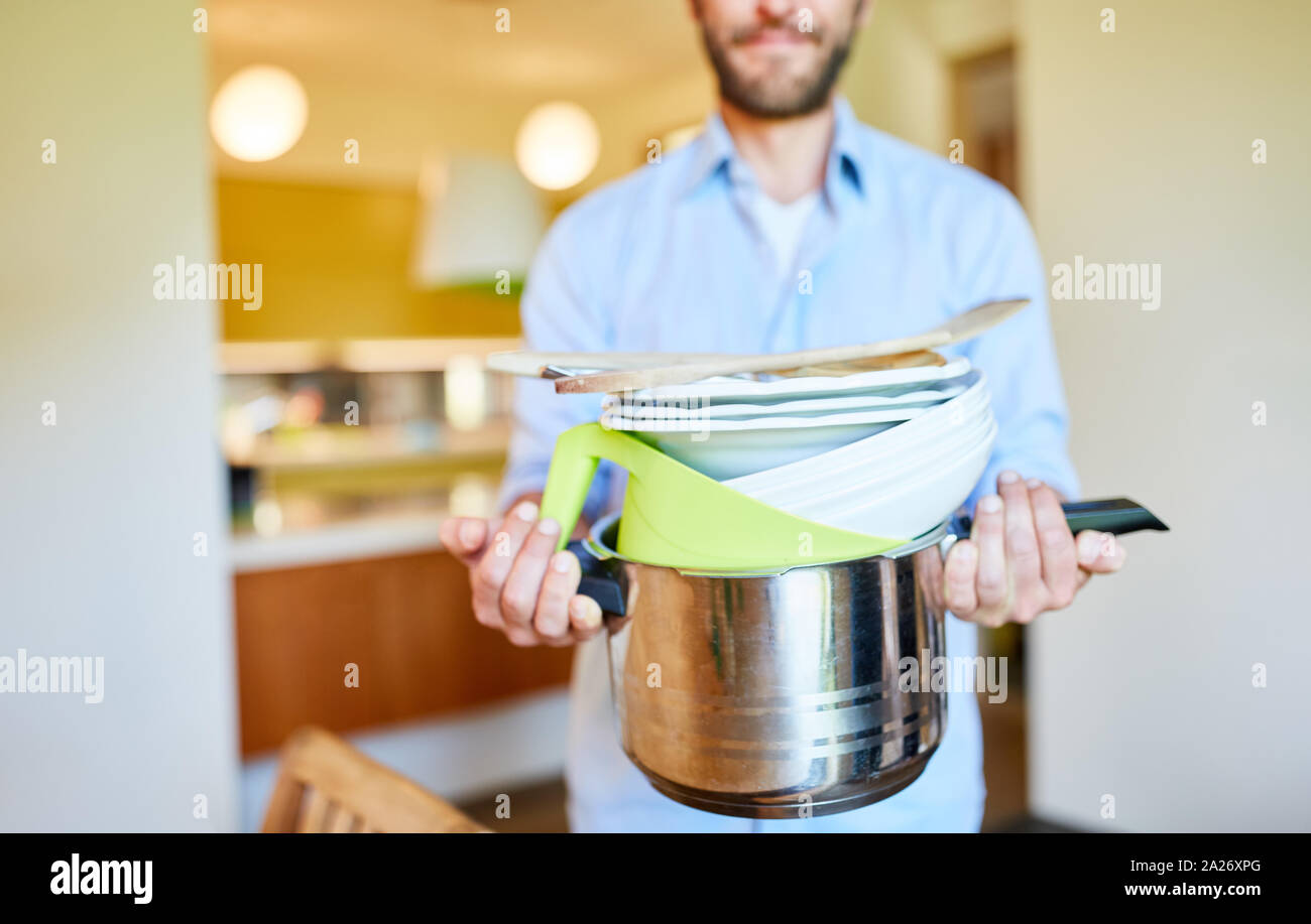 Houseman trägt sauber Topf und Geschirr in der Küche für die Emanzipation Stockfoto
