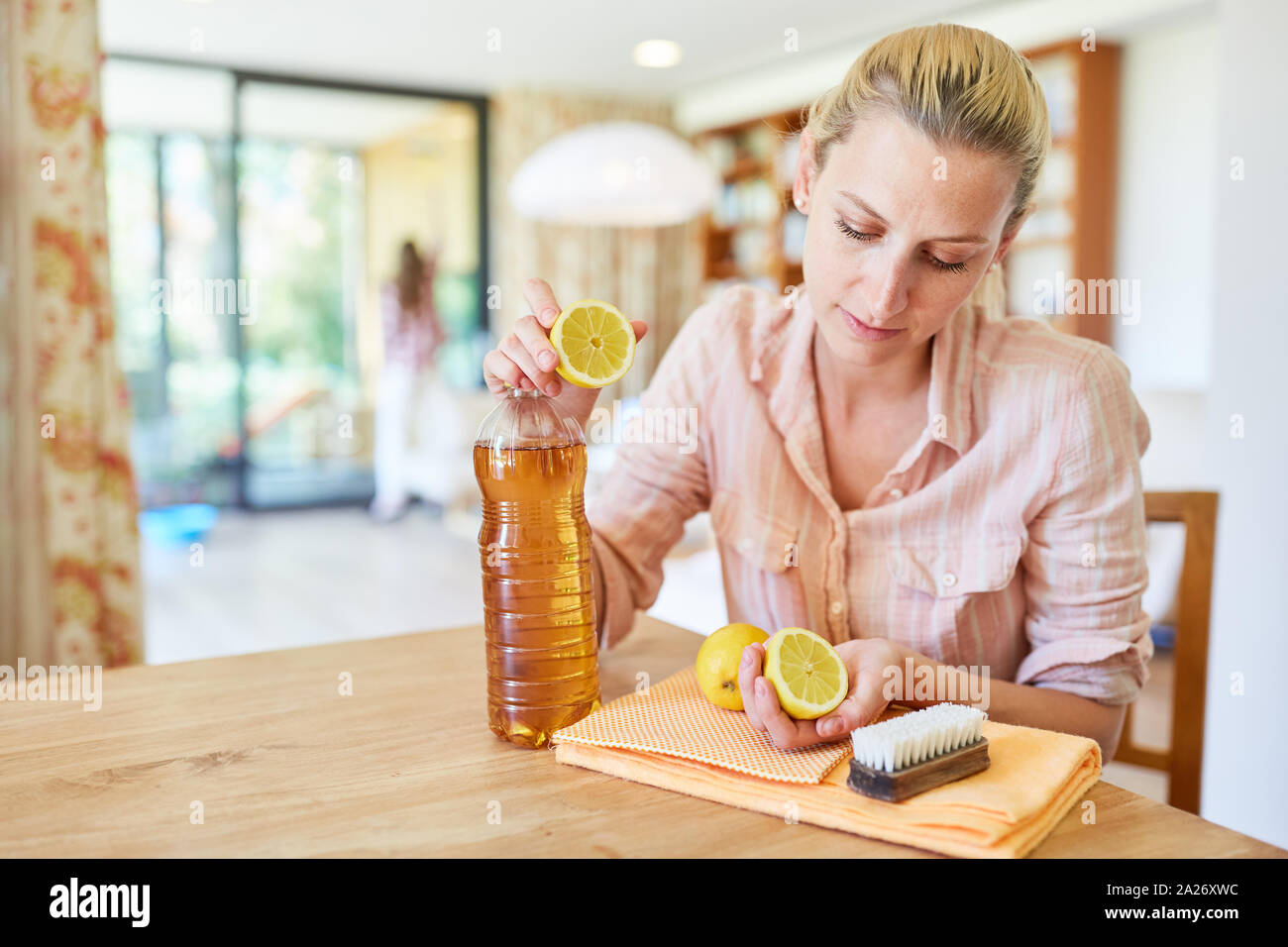 Hausfrau mischt ein Haupthilfsmittel für die Reinigung mit Zitrone und Essig Stockfoto
