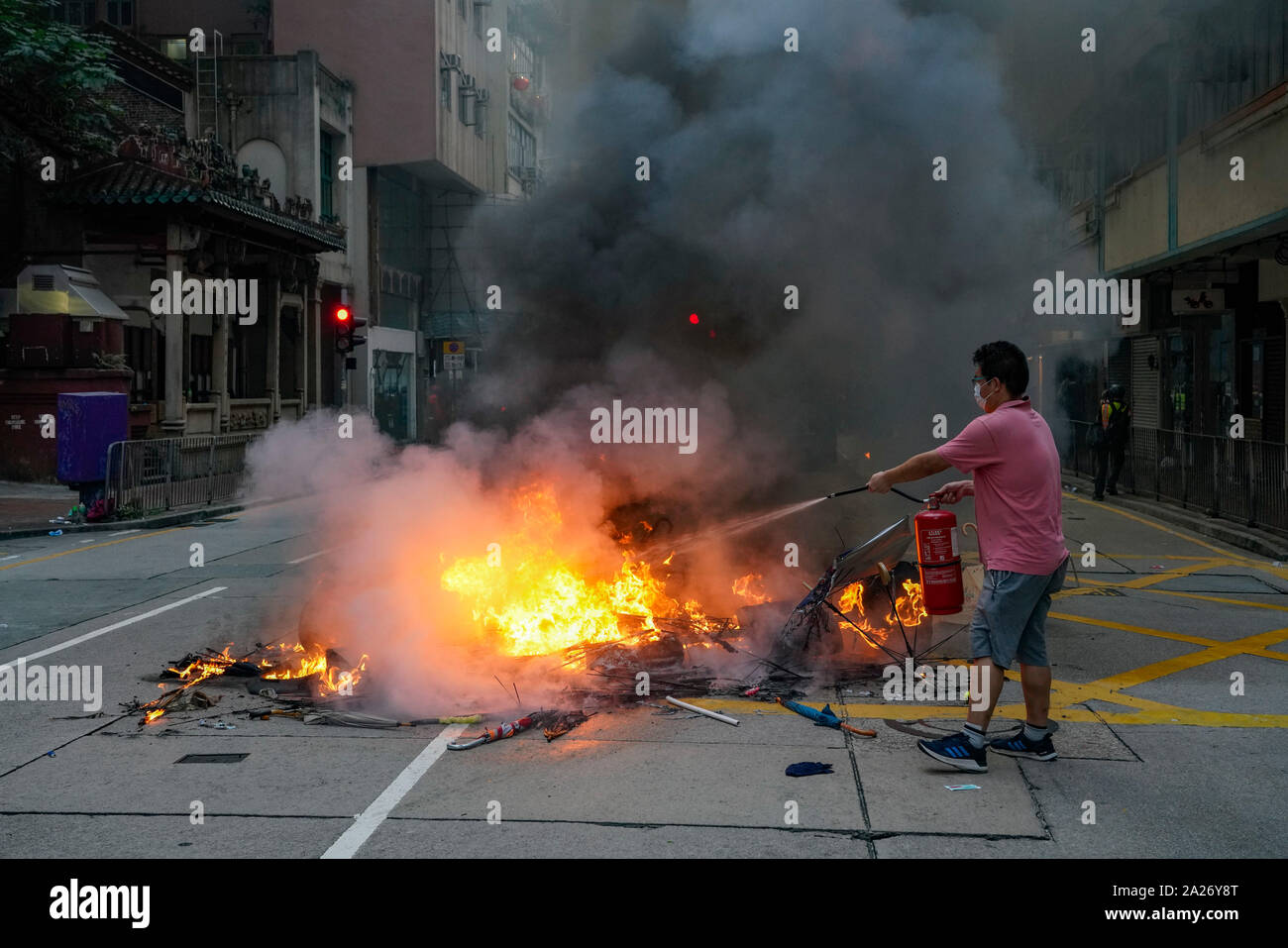 Hong Kong. 1. Oktober 2019. Nach einem friedlichen Marsch durch Hong Kong Island von schätzungsweise 100.000 pro Demokratie Unterstützer, gewalttätige Flammte auf Tamar, Admiralty und bewegte sich durch Wanchai Bezirk. Die Polizei setzte Tränengas und Knüppel Umläufe und Wasserwerfer. Harter Kern Gruppe Feuer, warf Steine und Molotow-Cocktails auf Polizisten. Die Gewalt in den Abend. Lokale man verwendet die Feuerlöscher auf Feuer auf Straße in Wanchai. Iain Masterton/Alamy Leben Nachrichten. Stockfoto