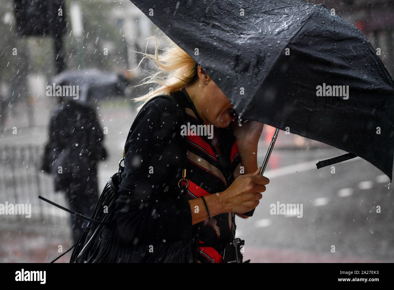 Menschen machen sich auf den Weg durch ein heftiger Regenschauer in Birmingham, Dienstag, 1. Oktober 2019. Siehe PA Geschichte Wetter im Herbst. Photo Credit: Jacob König/PA-Kabel Stockfoto