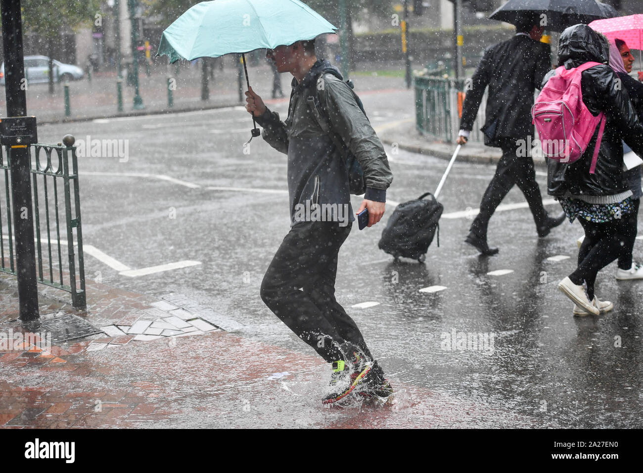 Menschen machen sich auf den Weg durch ein heftiger Regenschauer in Birmingham, Dienstag, 1. Oktober 2019. Siehe PA Geschichte Wetter im Herbst. Photo Credit: Jacob König/PA-Kabel Stockfoto