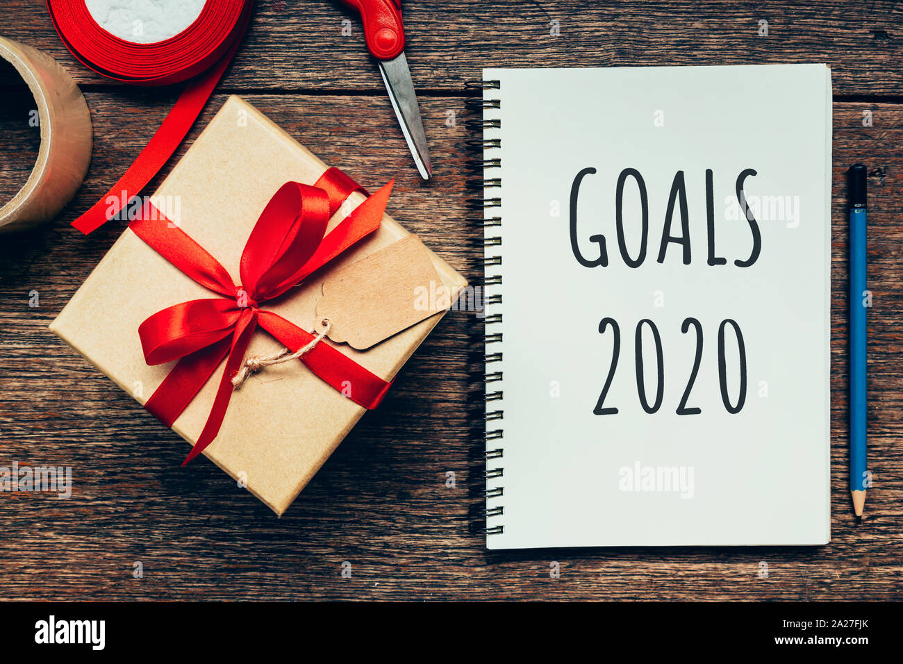 Neues Jahr Konzept. Ziele 2020 und Notepad, Geschenkbox Holztisch mit Kopie Raum Stockfoto