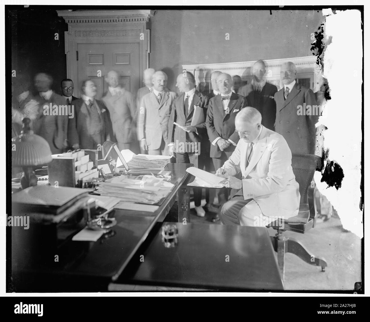 Pres Harding Unterzeichnung des Edge-Ansorge Auflösung für die Entwicklung der New York Hafen entlang der Linien, die von der Gemeinsamen Kommission von N.Y. und N.J. in den Vertrag vorgeschlagen, die die beiden Staaten am 30. April 1921 eingetragen. Der Vertrag sieht die allgemeine Befreiung von der Hafen von Staus und war durch den Krieg Abteilung gebilligt. Rep. Martin C. Ansorge, oder New York, Sponsor der Entschließung steht (Dritte) von Präsident Harding, mit Papieren unter dem Arm Stockfoto