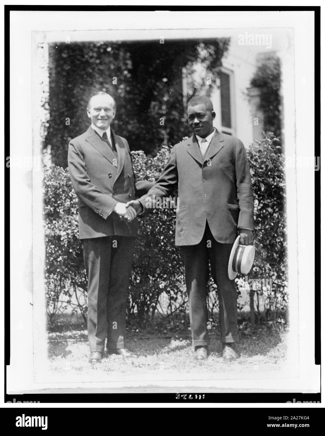 President Coolidge und Thomas Lee, Mississippi River hero, full-length Portrait, stehend, Hände schütteln Stockfoto
