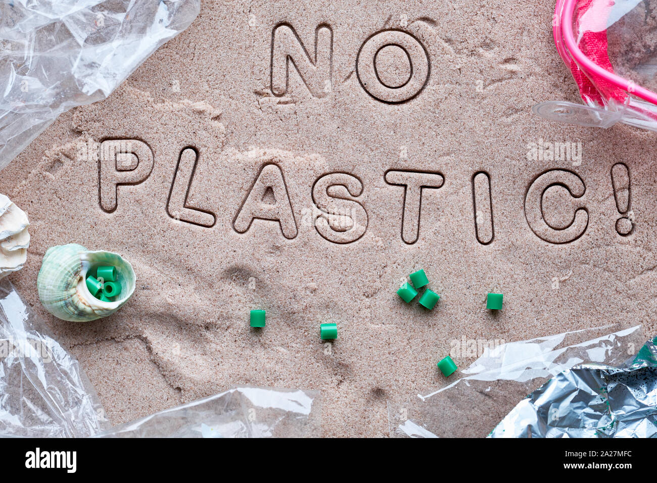 Kein Kunststoff text auf Sand mit verschiedenen Ablagerungen eingerahmt. Die Verschmutzung ist schädlich für die marine Leben. Umweltkonzept. Verbot single use Kunststoff Kampagne. Stockfoto