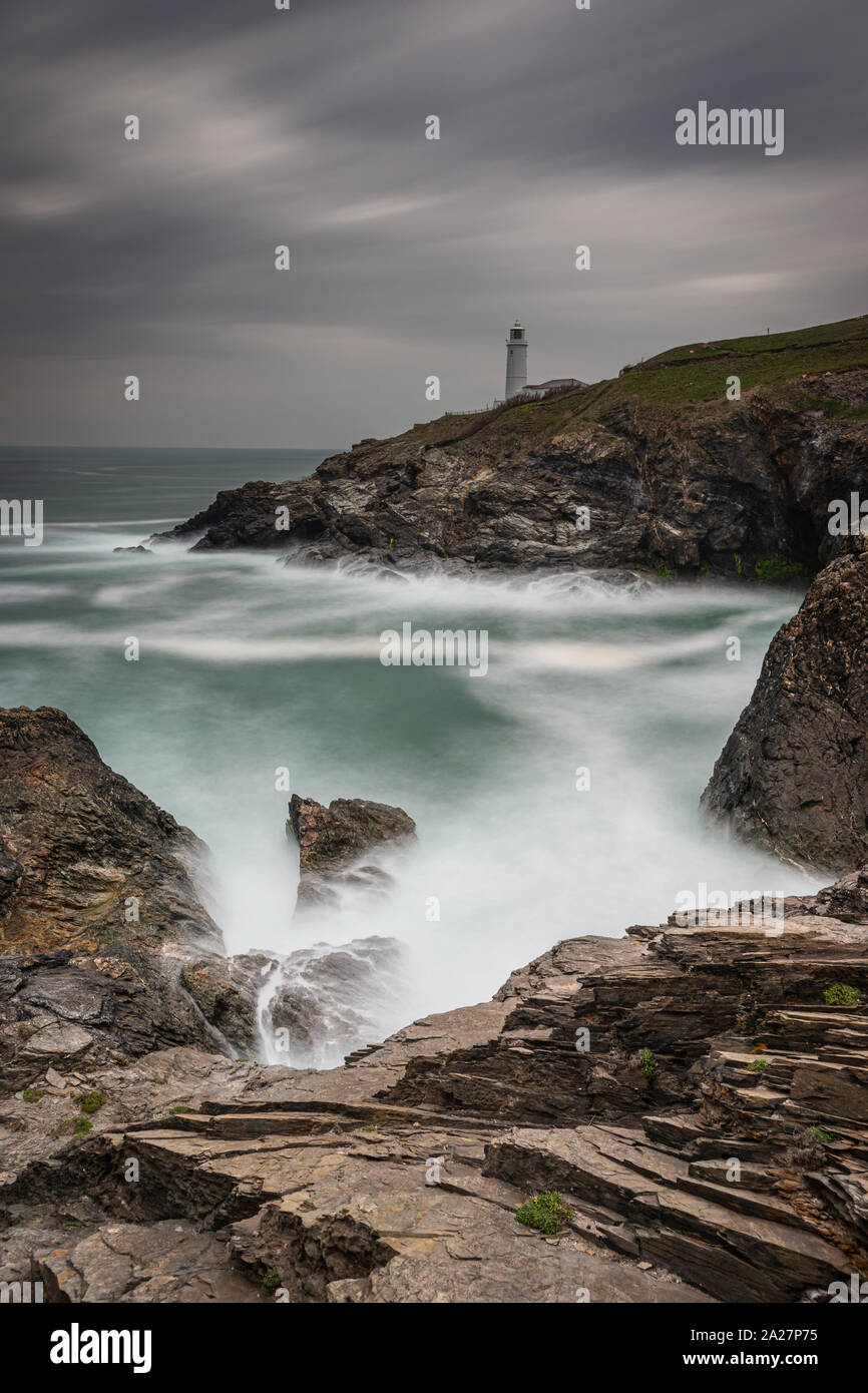 Trevose Head Lighthouse in North Cornwall mit einem stürmischen Himmel und Wellen auf die Felsen macht eine schöne zerklüftete Landschaft Stockfoto