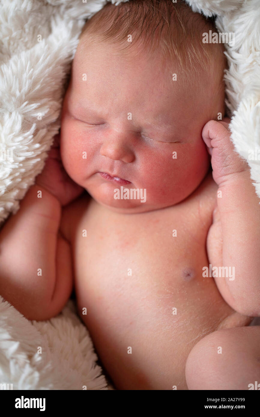 Eine schöne New Born Baby schlafen in einem Fell Decke Stockfoto