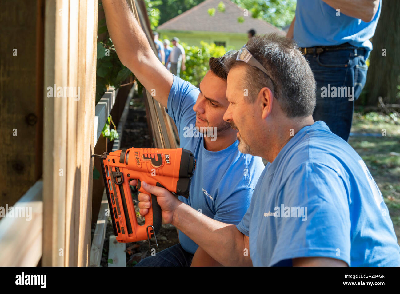 Detroit, Michigan - die Freiwilligen von Cooper Standard installieren übung Ausrüstung und Fechten in einer neuen Gemeinschaft Morningside Park in der Nachbarschaft. Stockfoto