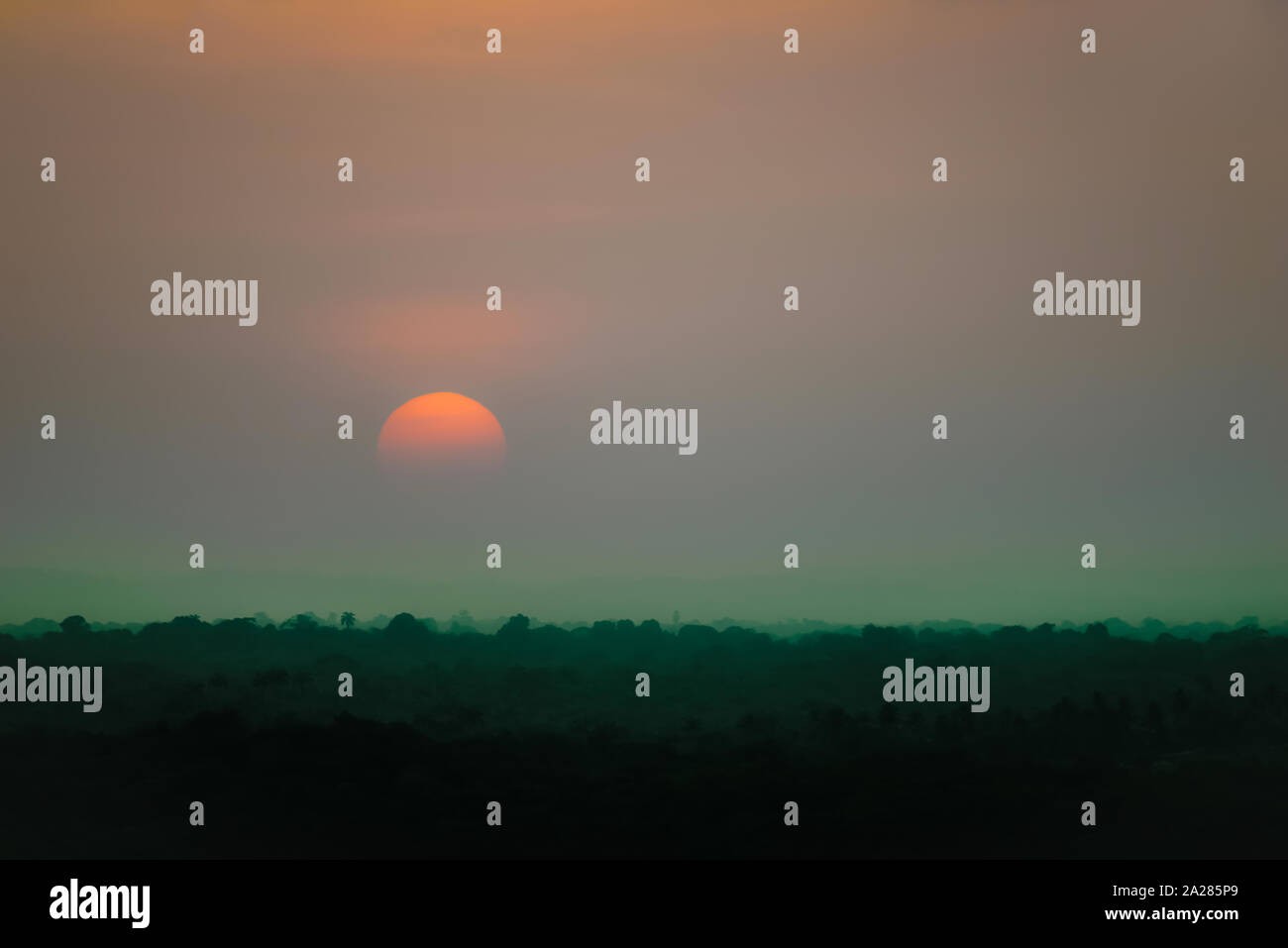 Mystic Sonnenuntergang Szene von tropischen Wald dunkel Orange Sun grüne Dämmerung natürliche Spooky Stockfoto