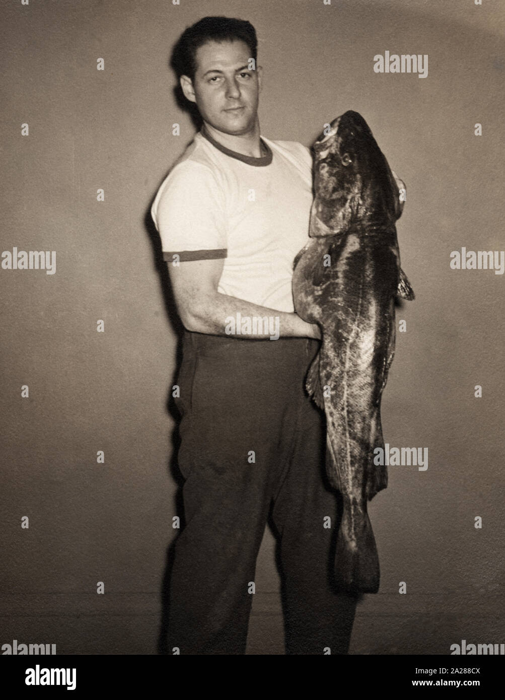 Vintage Foto von einem Mann mit einem großen Bass Fisch, ca. 1950er-Jahre. Stockfoto