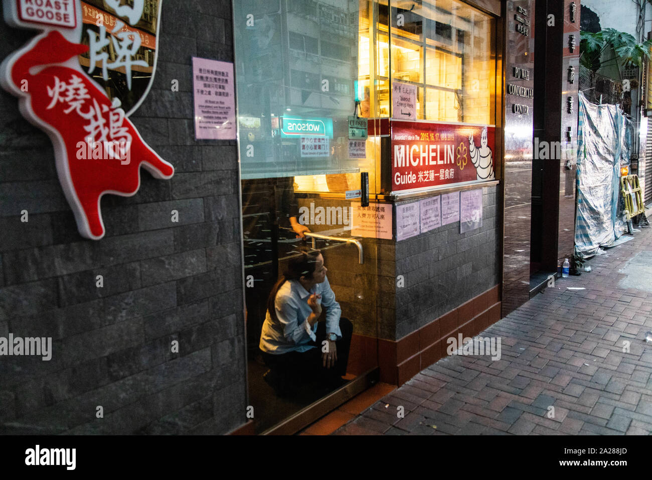 Hongkong, China. 01 Okt, 2019. Ein Restaurant-Server erfolgt vorsichtig ein Peep draußen während der Demonstration. In der 18. Woche der Unruhen, die demonstranten am Morgen von Chinas nationalen Tag, den der 70. Jahrestag der Volksrepublik China feiert in diesem Jahr marschierten. Die Demonstranten skandierten Parolen und fuhr fort zu Fragen für die fünf Forderungen erfüllt werden. Die Demonstranten zu Zusammenstößen zwischen Polizei und wurden mit Gas, Gummigeschossen und Wasserwerfern und schließlich viele wurden festgenommen. Credit: SOPA Images Limited/Alamy leben Nachrichten Stockfoto