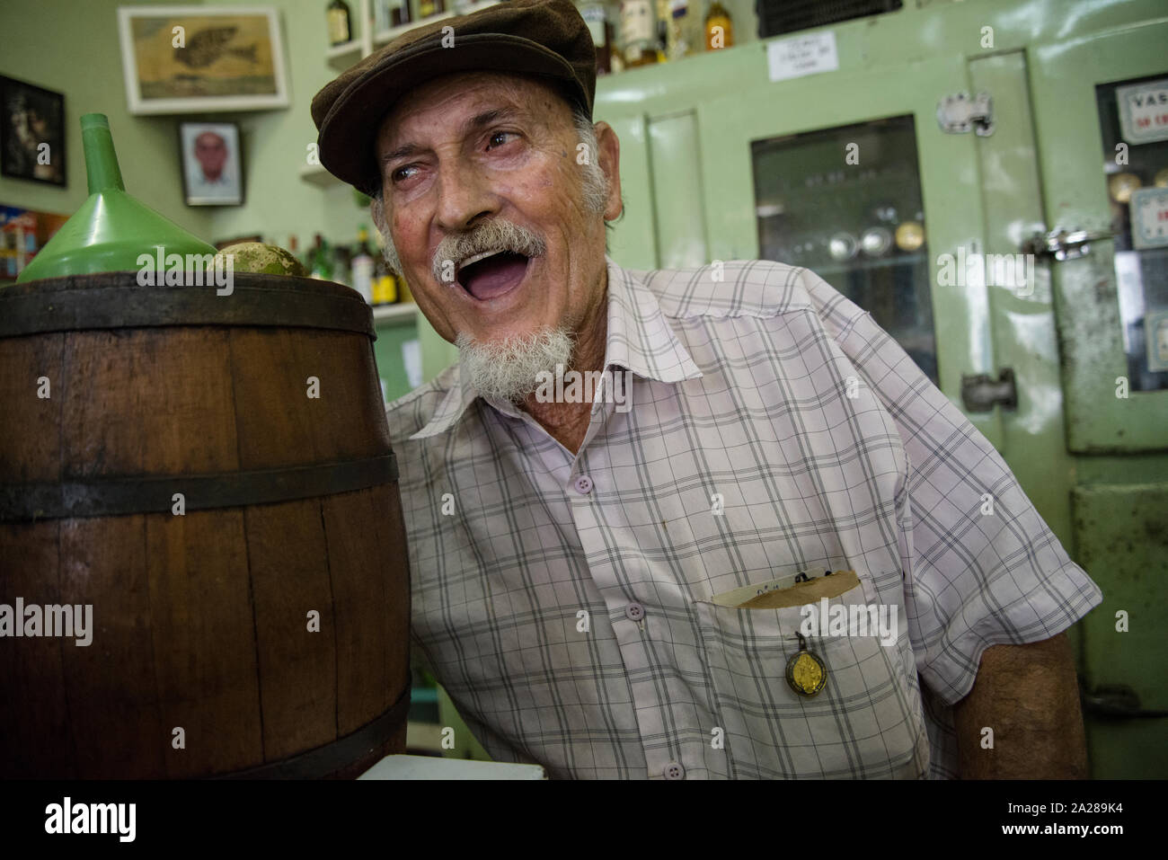 Eigentümer der alten Pub hinter der Theke und ein cachaca Holz Fass Stockfoto