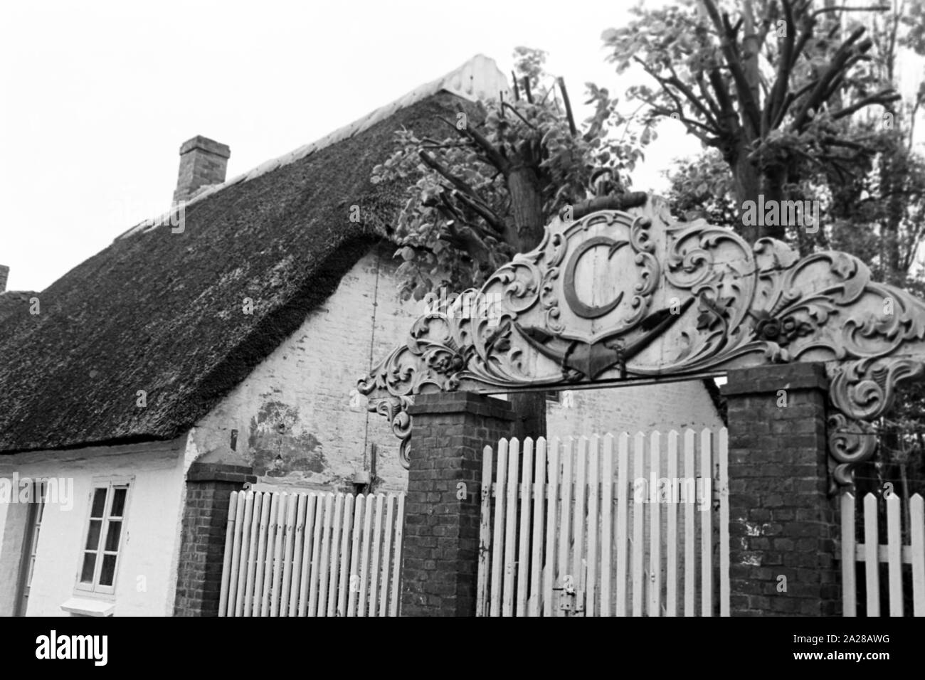 Malerisches altes Haus mit Hofeinfahrt in Wy auf der Insel Föhr, Deutschland 1960er Jahre. Scenic altes Haus mit Hof Eingang in Wyk Auf Foehr Insel, Deutschland der 1960er Jahre. Stockfoto