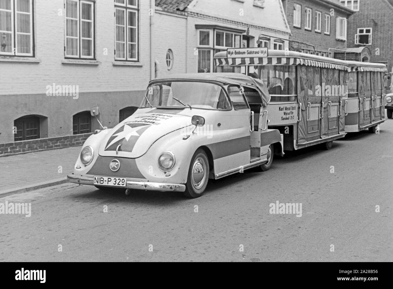 Kässbohrer Transport Zugmaschine mit Bimmelbahn auf der Insel Föhr, Deutschland 1960er Jahre. Kaessbohrer öffentliche Verkehrsmittel Zug auf Foehr Insel, Deutschland der 1960er Jahre. Stockfoto