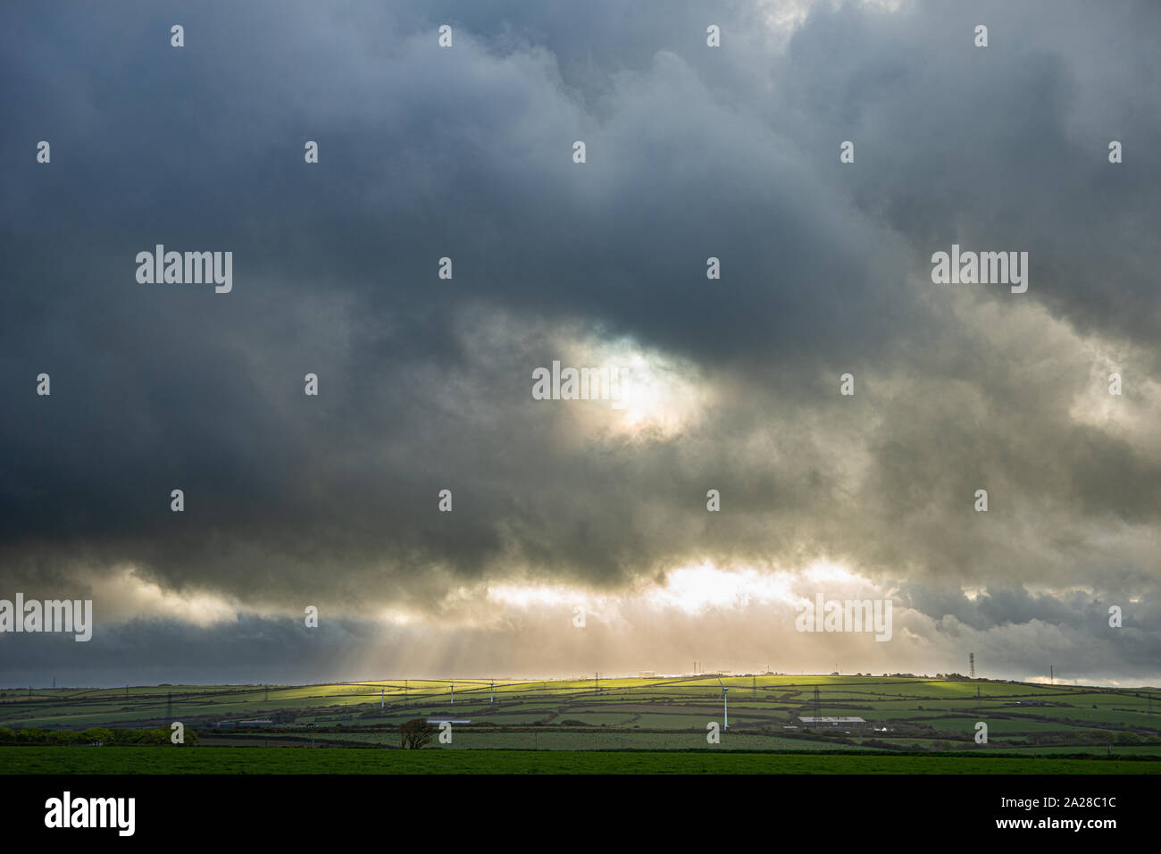 Stürmischen Himmel über Cornwall mit einem Bruch in den Wolken Hervorhebung Pylone Stockfoto