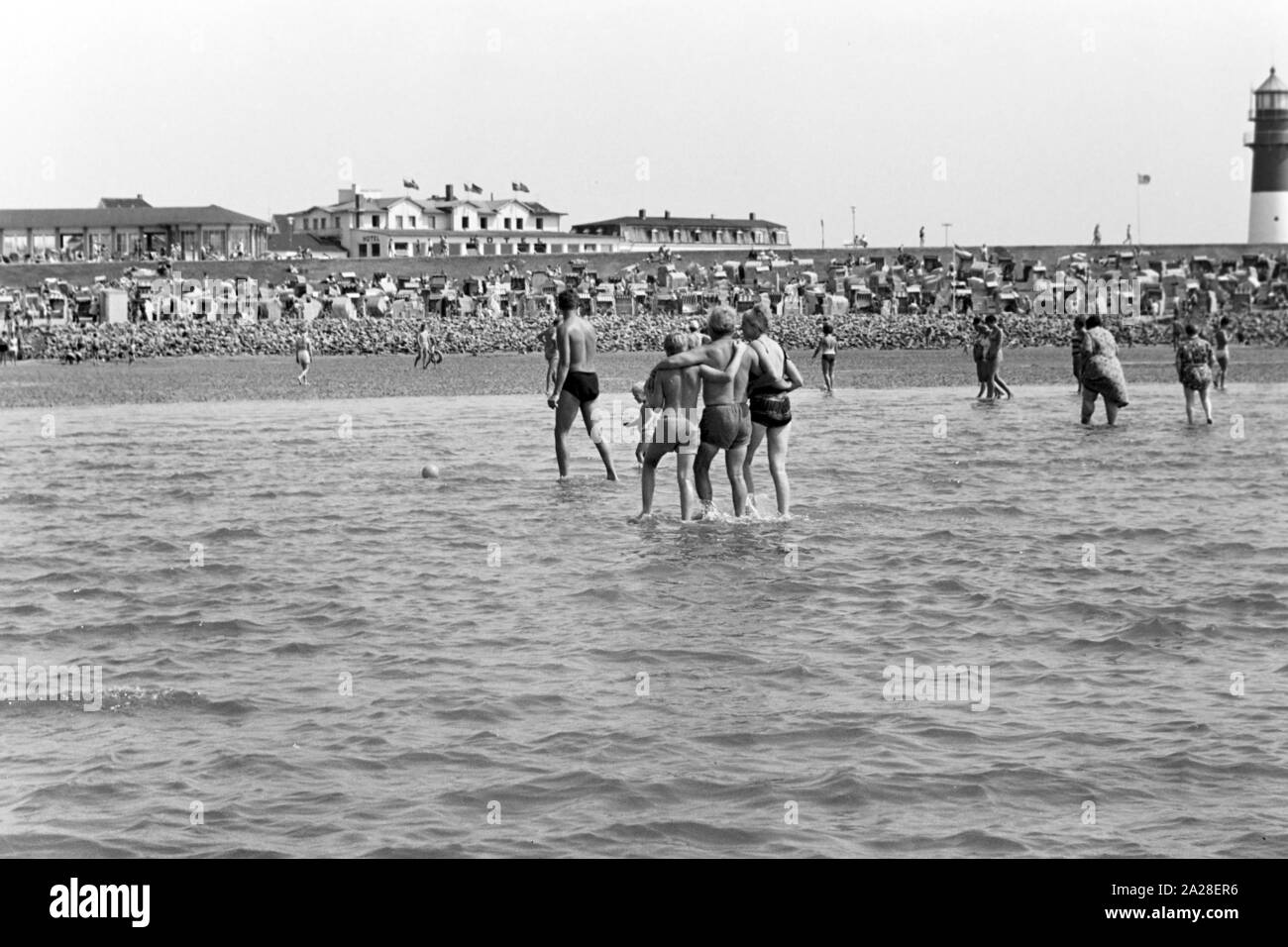 Menschen beim Strandvergnügen in Büsum, Deutschland 1960er Jahre. Menschen Spaß am Strand in der Nähe des Buesum, Deutschland der 1960er Jahre. Stockfoto