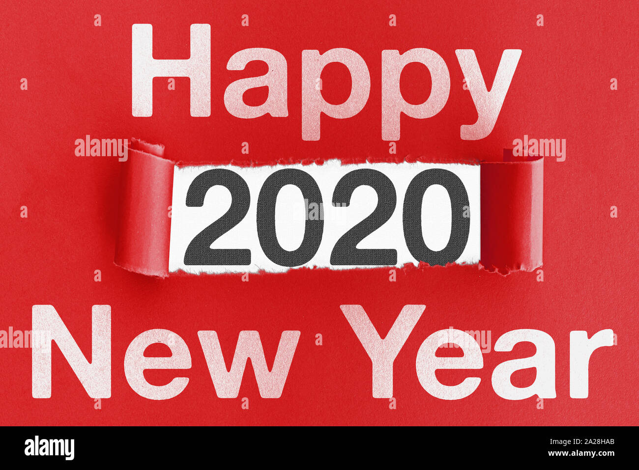 Wort FROHES NEUES JAHR auf zerrissenes rotes Papier mit Zahlen 2020 in Öffnung Stockfoto