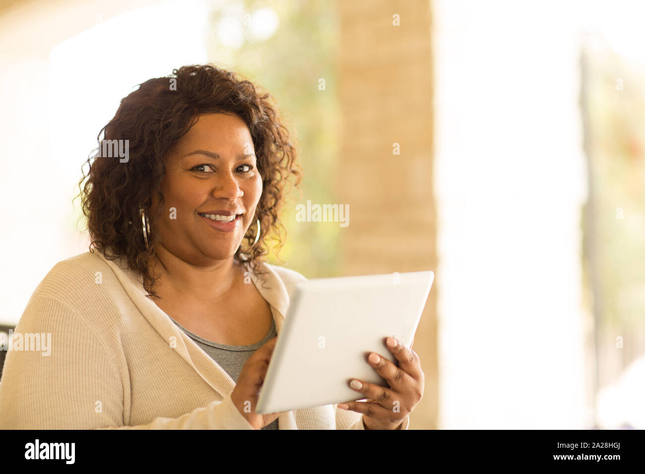 Lächelnd afrikanische amerikanische Frau an einer Tablette. Stockfoto