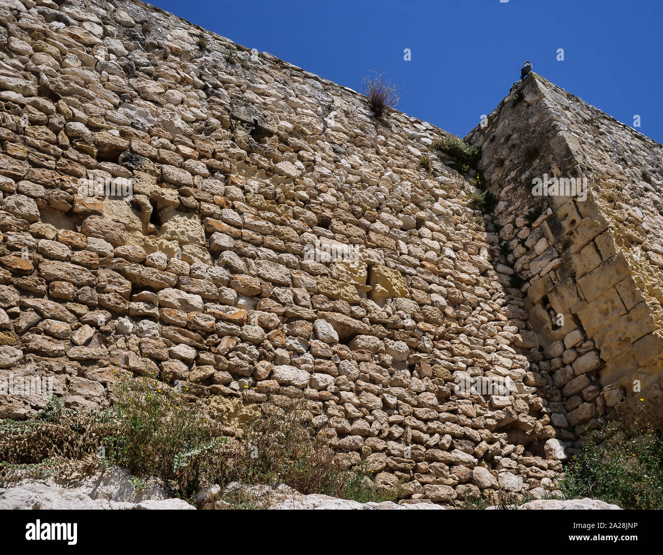 Ein Teil der alten Architektur, alte Steinmauer vor blauem Himmel Stockfoto