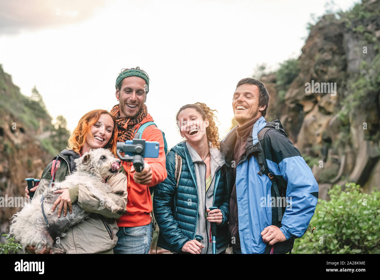 Gerne Freunde Aufzeichnen von Videos mit Mobile Smartphone Kamera auf die Berge bei Sonnenuntergang - Junge Leute wandern und Spaß mit neuer Technologie Trends Stockfoto