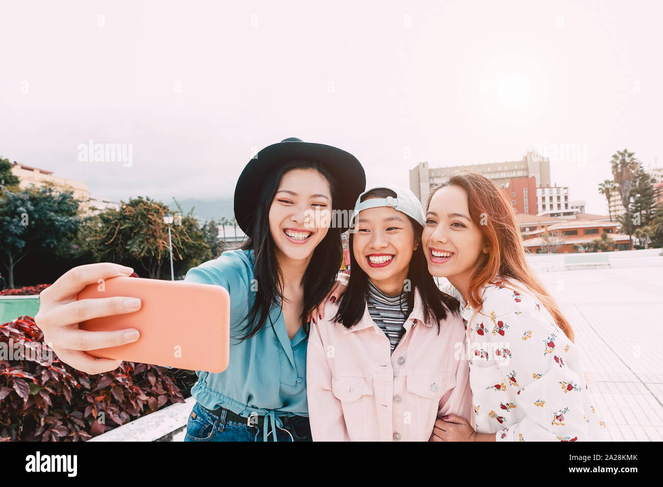 Gerne asiatische Mädchen unter selfie mit Mobile Smartphone outdoor - junge trendige Teenager Spaß mit neuer Technologie app Stockfoto