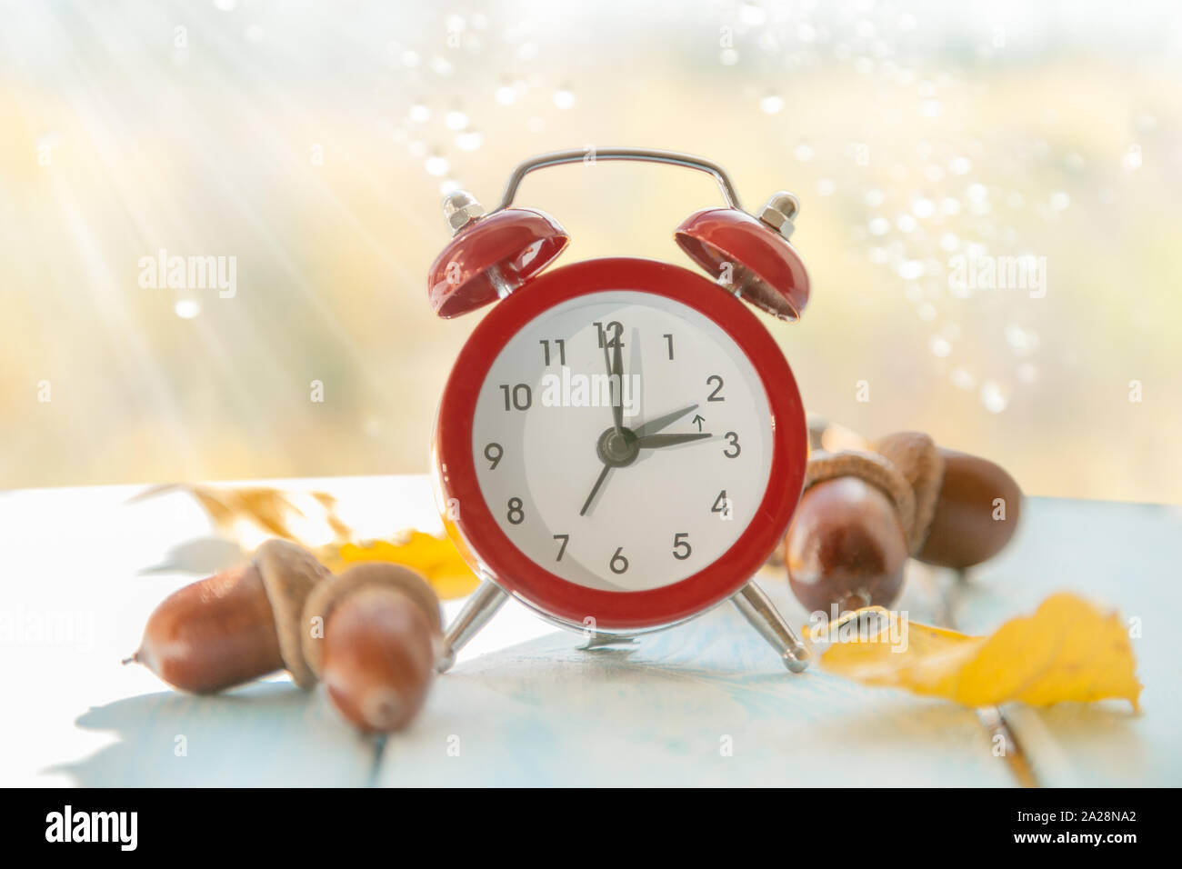 Herbst Zeit ändern Konzept - rot Wecker auf Holz Hintergrund Stockfoto