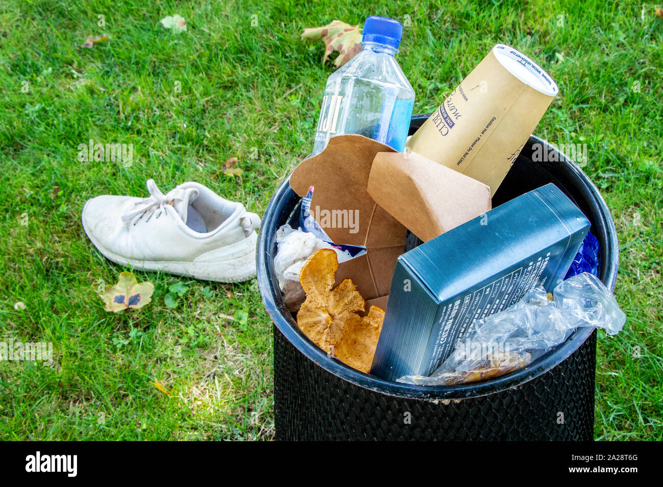 Park Abfallbehälter gefüllt mit random Müll, gemischt von Müll und ein verlegtes Schuh Stockfoto