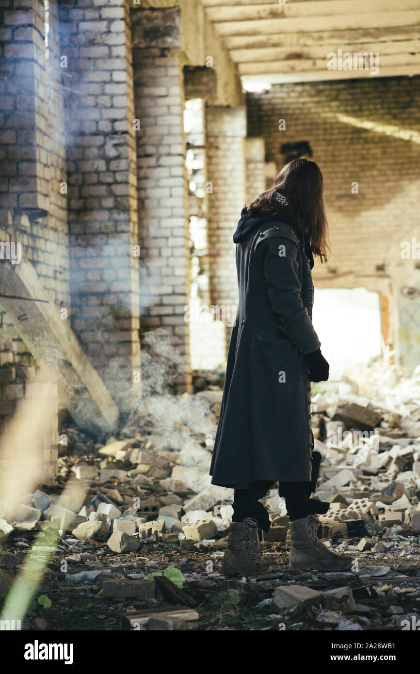 Junge Mann in den Ruinen post Apokalypse auf Erden, Licht von hinten, Rauch für den Hintergrund. Stockfoto