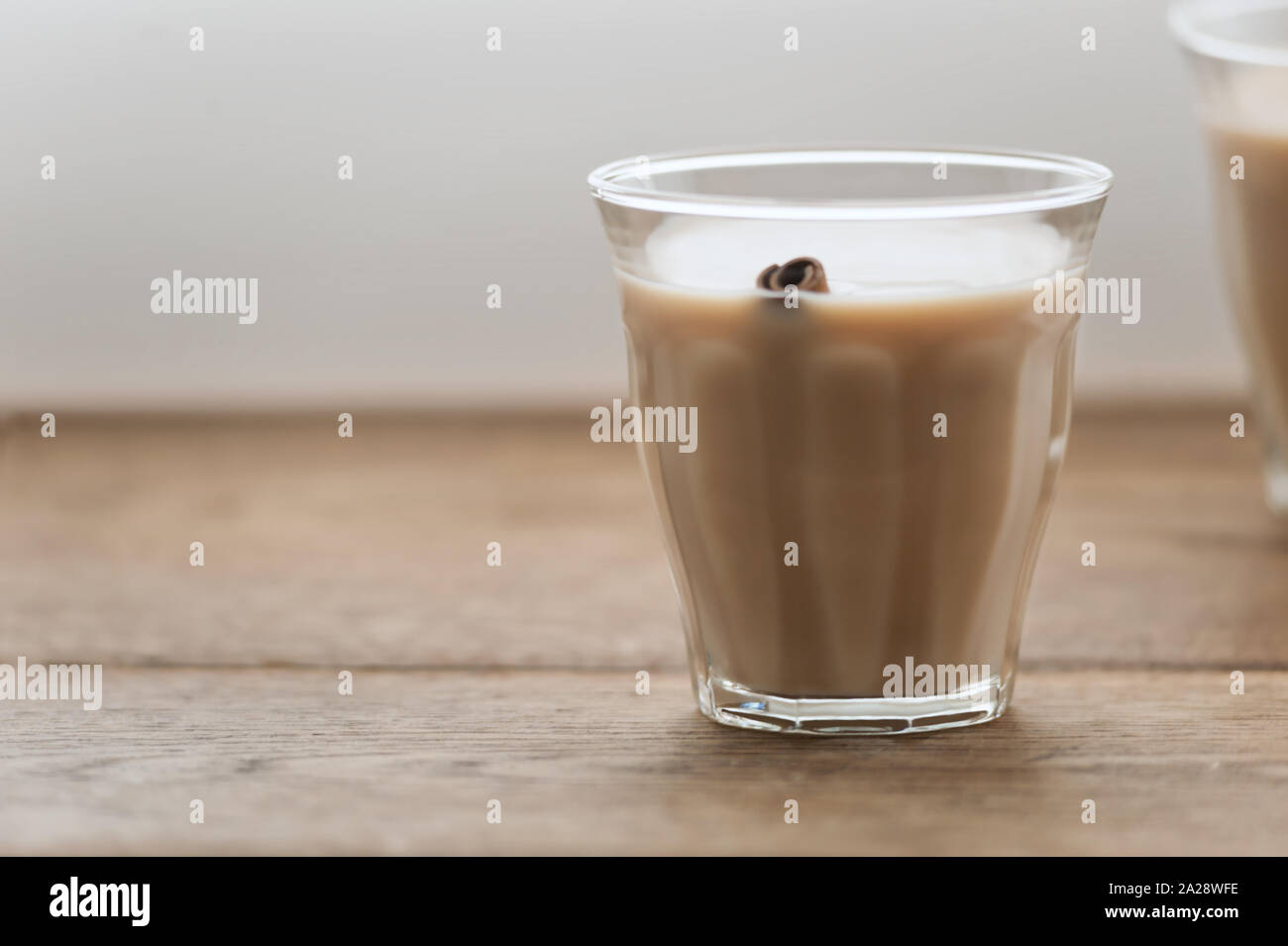 Pikant Masala Chai mit Milch in ein Glas und eine Zimtstange über sie in Holz- Hintergrund. Selektive konzentrieren. Bild mit Kopie Raum, horizontal. Stockfoto