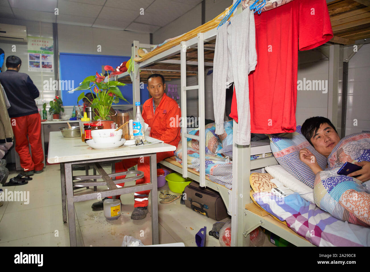 China Hangzhou, die Migranten aus den Dörfern arbeiten in der großen Stadt schlafen in einen Behälter mit 10 Personen in einem Zimmer. Arbeiten an einem Tunnel proj Stockfoto